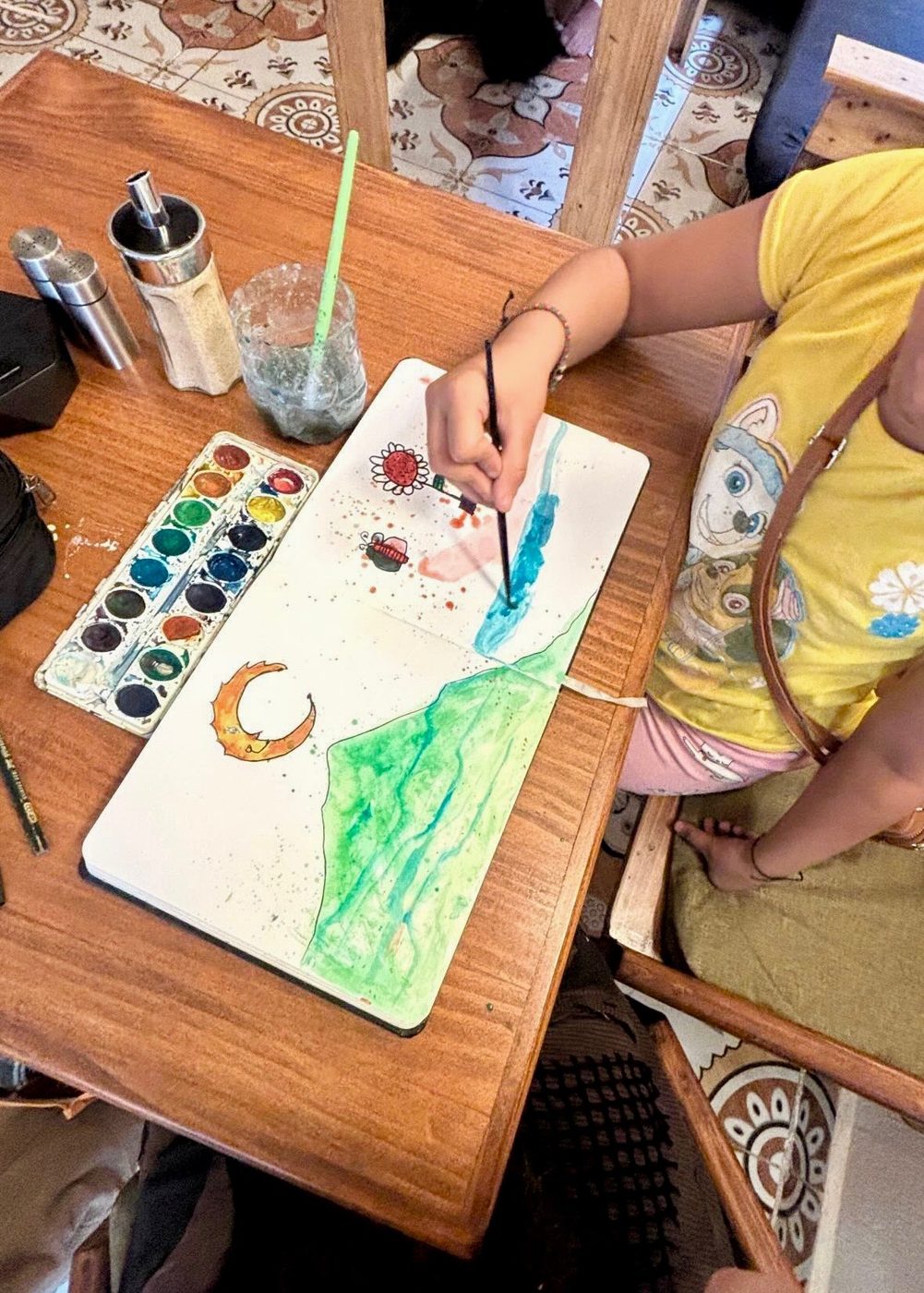 A child painting a watercolor landscape at Espiral